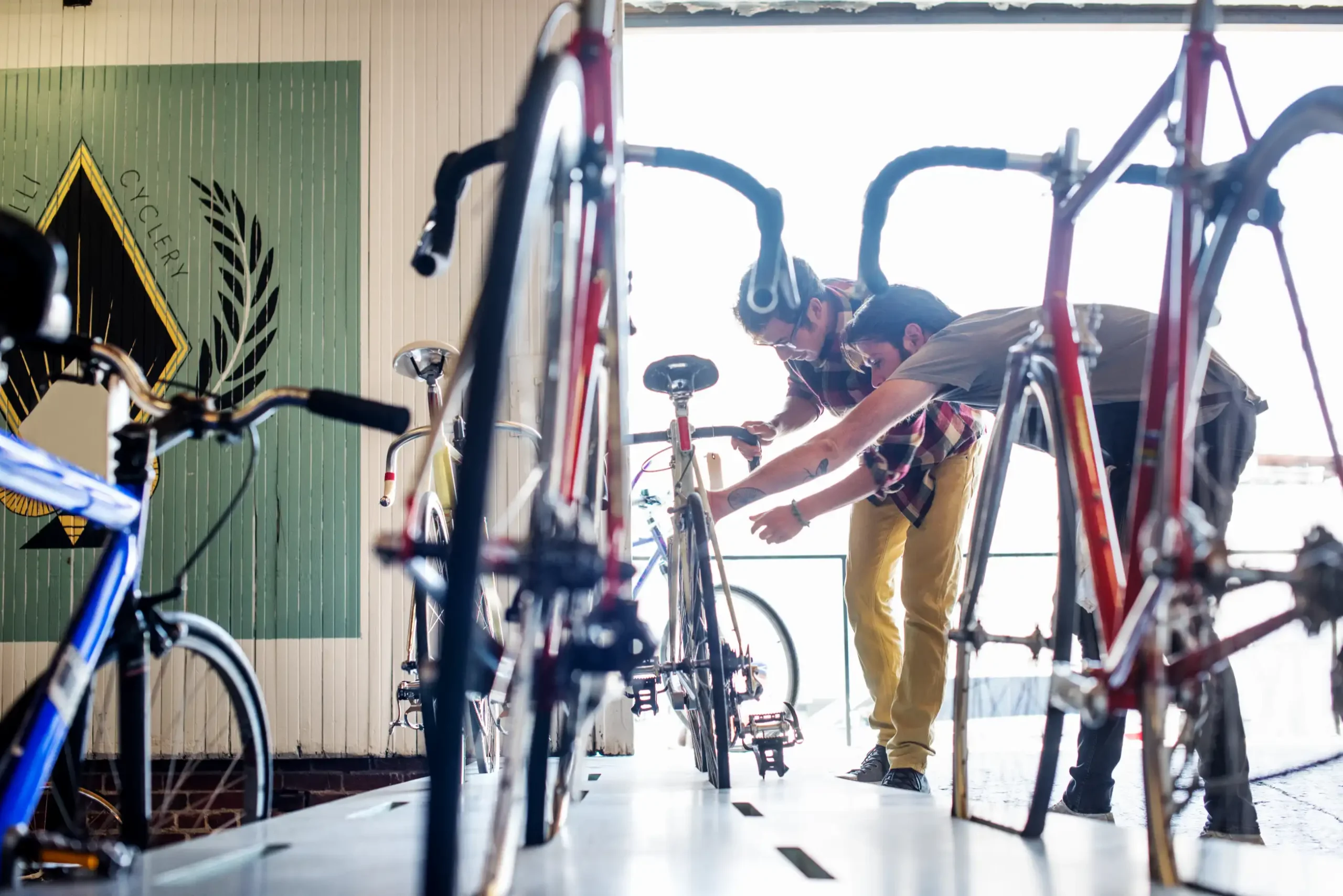 Two people inspecting bike tires and brakes before using bike rentals.