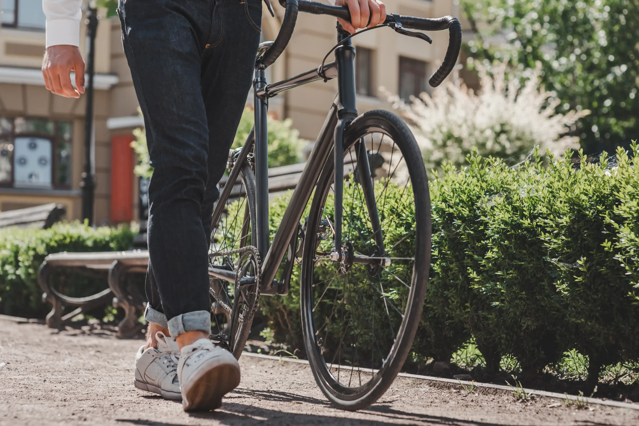 Cyclist walking their bicycle to a repair shop for routine bike repairs, ensuring optimal performance and safety.